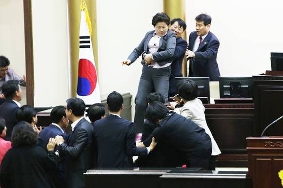 의장석 단상을 지키던 새누리당 남경순 의원이 야당 소속 의원들과 몸싸움을 벌이고 있다.(사진=연합뉴스)