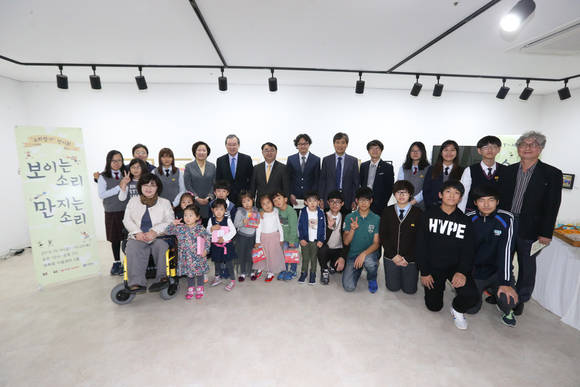 16일 금요일 오후 ‘KT-세브란스 소리찾기 전시회’ 개소식에서 이번 전시를 마련한 KT와 연세의료원 관계자, KT꿈품교실 참가 학생들이 기념사진을 촬영하고 있다. (사진제공=KT)