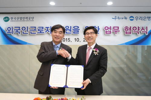 22일 서울 우리은행 본점에서 이광구 은행장(사진 오른쪽)이 한국산업인력공단과 외국인 근로자 지원을 위한 업무협약을 체결한 후 박영범 이사장과 기념촬영을 하고 있다. (사진제공=우리은행)