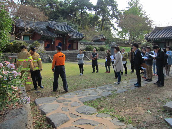 광산구 관계장 등이 행복학습센터와 작은도서관이 있는 무양서원 점검에서 관리자와 주민이 함께 옥외 소화전 사용법, 소화기 사용법, 화재 발생 시 초동 대처 방법 등을 소방관의 지도로 함께 배우고 있다.(사진=광산구)