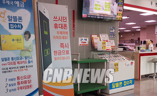 알뜰폰 단말기들이 전시된 매대와 가입 방법을 설명하는 안내판. (사진=이성호 기자)