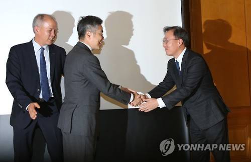 지난해 11월 30일 국내 첫 인터넷전문은행 사업자로 선정된 카카오뱅크 윤호영 카카오 부사장(오른쪽)과 케이뱅크 김인회 단장이 30일 오전 서울 명동 은행회관에서 사업계획 브리핑을 하기에 앞서 악수하고 있다. 뒷쪽은 이용우 한국투자금융 전무. (사진=연합뉴스)