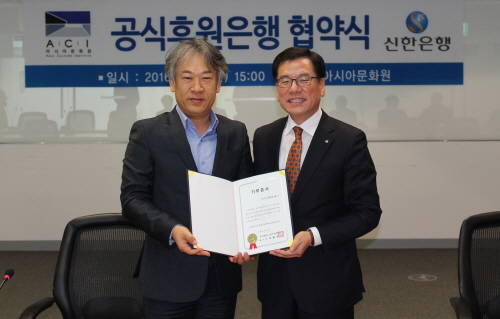 윤상돈 신한은행 부행장(오른쪽)과 김병석 아시아문화원 원장(왼쪽)이 14일 광주광역시 소재 국립아시아문화전당 대회의실에서 진행된 ‘아시아문화원 공식후원은행 업무협약’ 체결 후 기념 촬영하는 모습. (사진제공=신한은행)