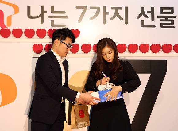 갤럭시 S7 1호 가입자 이건희(26세) 고객에게 지급되는 스케이트에 김연아 선수가 싸인을 하고 있다. (사진제공=SK텔레콤)