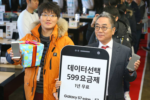 갤럭시 S7과 갤럭시 S7 엣지 출시일인 11일 오전 서울 광화문 KT스퀘어에서 1호 개통자 이원구 씨(왼쪽)가 KT IMC본부장 이동수 전무와 기념촬영을 하고 있다. (사진=연합뉴스)