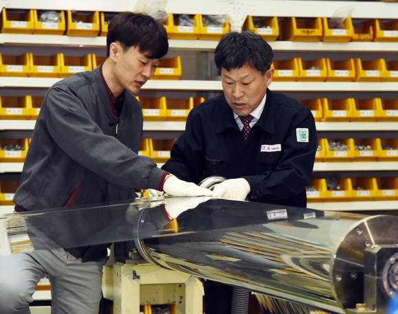 제이에스텍 윤중식 대표(오른쪽)와 LG화학 담당자가 공동 개발해 국산화에 성공한 광학필름 가공설비 석션롤을 점검하고 있다. (사진제공=LG그룹)