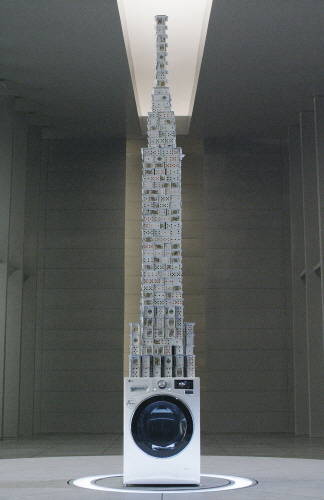 LG전자가 ‘카드쌓기’ 세계기록 보유자 브라이언 버그와 함께 LG 저진동 드럼세탁기 위에 3.3m 높이의 카드탑을 쌓는 데 성공했다. (사진제공=LG전자)