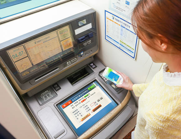 삼성전자 모델이 ‘갤럭시 S7’으로 ATM 서비스를 이용하고 있다. (사진제공=삼성전자)