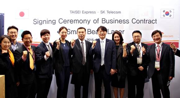 SK텔레콤 김성한 Device기획본부장(왼쪽 7번째)과 일본 타이세이사 황경호 대표(왼쪽 6번째)가 UO스마트빔레이저 일본 수출 계약을 체결했다. (사진제공=SK텔레콤)