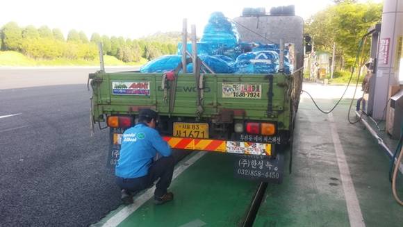 주암주유소가 지난 20일 화물차 이용고객을 대상으로 후방차량에게 전방 차량의 식별을 쉽게 하는 후부반사지를 닦아주고 노후한 반사지는 교체해주고 있다.(사진=주암주유소)