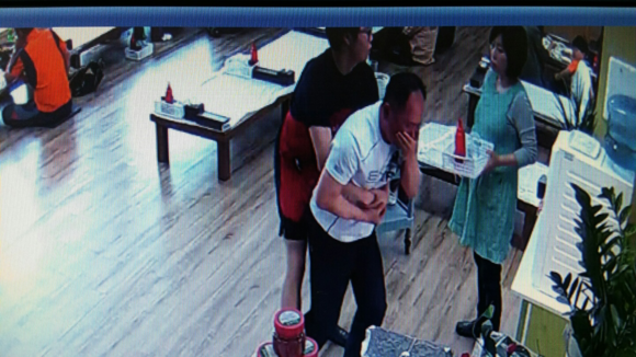 윤장군씨가 낙지가 기도에 걸린 손님을 응급조치하고 있는 CCTV 모습.