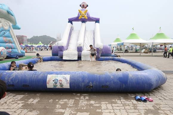 2016 화성 뱃놀이 축제에 온 아이들이 미끄럼틀에 몸을 맡기고 신나는 머드체험에 푹 빠져 있다.(사진=화성시)