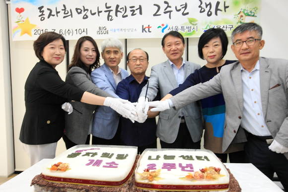 KT-서울시-서울역쪽방상담소 관계자들이 동자희망나눔센터 개소 2주년 기념 떡 케익을 커팅하고 있다. (사진제공=KT)