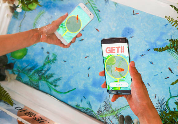 ‘갤럭시 S7’ 체험존에서 참가자들이 IP68 방수방진 기능을 활용한 ‘물 속에서 물고기 잡기’ 게임을 하고 있다. (사진제공=삼성전자)