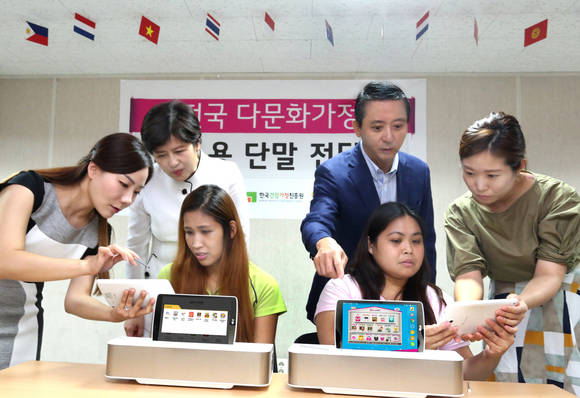 강은희 여성가족부 장관(뒷줄 왼쪽 첫번째), 권영수 LG유플러스 부회장(뒷줄 왼쪽 두번째)이 결혼이주여성들과 함께 교육용 단말을 시연하고 있다. (사진제공=LG유플러스)