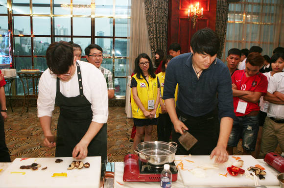 20일(현지시간) 베트남 하노이에서 열린 ‘한국·베트남 가족화합의 밤’ 행사에서 오세득(왼쪽), 최현석(오른쪽) 셰프가 베트남 현지가족 및 교민들과 함께 양국의 전통요리를 만들고 있다. (사진제공=KT)