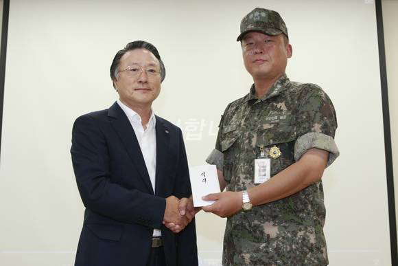 26일 제주 강정 해군기지에 방문한 김임권 수협중앙회장(왼쪽)이 강동길 제주기지 전대장에게 격려금을 전달하고 있다. (사진제공=수협중앙회)