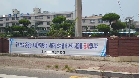 목포 S초등학교가 납 검출로 우레탄 트랙 사용금지가 아닌 새롭게 보수할 때까지 사용 금지를 알리는 현수막.