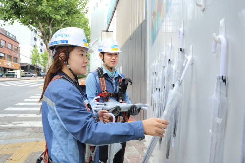 서울 강남 개포동에 위치한 래미안블레스티지 건설현장 가림벽에 우산을 걸고 있는 현장직원의 모습. (사진=삼성물산)