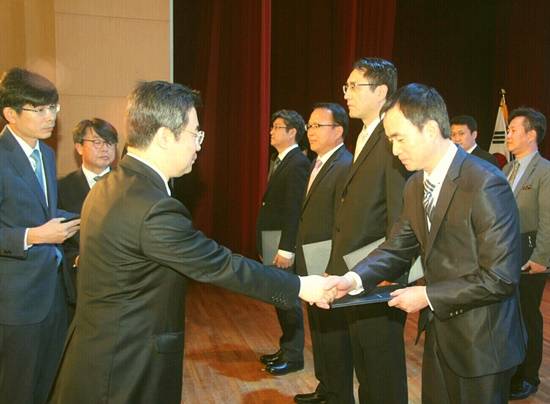 성문일렉트로닉스 이강일 대표를 대신해 노재필 부장이 산업통상자원부 우태희 차관으로부터 장관 표창을 받고 있다(사진= 성문일렉트로닉스)